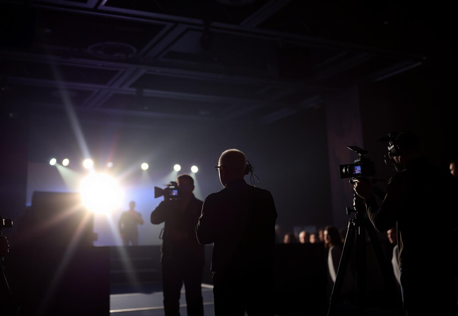 Press cameras and spotlights covering the summit stage